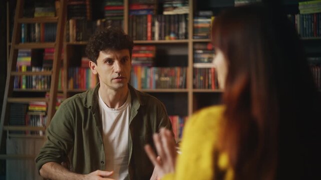 Young man argues with his girlfriend in coffee shop, facing relationship crisis