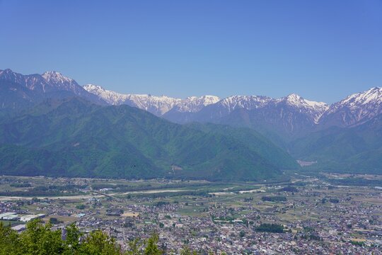 北アルプス　鷹狩山から望む残雪の北アルプスと新緑の大町市街