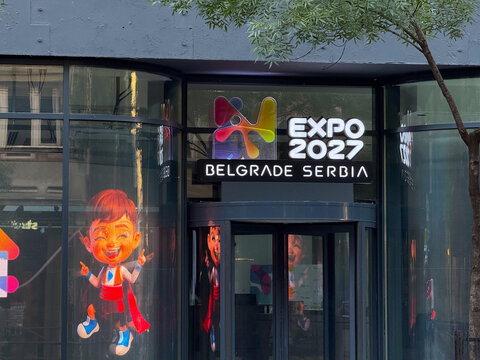09 August 2026, Belgrade, Serbia: Glass building entrance with Expo 2027 Belgrade Serbia sign and colorful logo. International exhibition, urban branding, and global event representation
