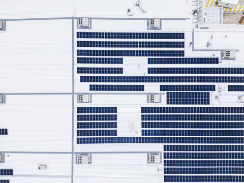 Aerial view of the solar panel array on the roof of a hospital, featuring rows of photovoltaic cells and HVAC units on a white surface in Chihuahua, Chihuahua, Mexico.