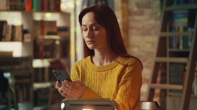 Sad young woman reads message on phone and leaves coffee shop after failed date