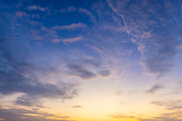 Fototapeta premium Beautiful Sunset Sky with Colorful Clouds and Golden Light,A stunning view of the evening sky filled with dramatic clouds, illuminated by the warm golden and orange light of sunset blending into.