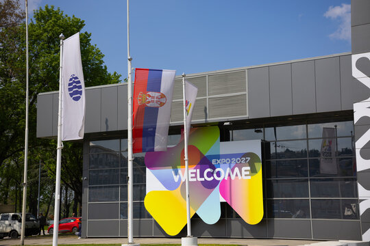 17 April 2026, Belgrade, Serbia: Expo 2027 welcome banner with Serbian flag in front of modern pavilion in Belgrade Serbia. International exhibition branding