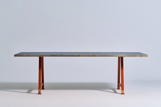 Modern dining table with a grey wooden top and red steel trestle legs, featuring an oiled finish for a furniture catalogue and e-commerce listing