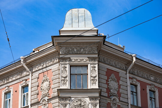 Ornate pink corner building with domed turret and pediment window