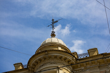 Weathervane and ornate dome of a historic building against blue sky © Mariia