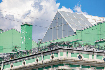 Weathered chimney and ornate cornice on a historic green building roof © Mariia