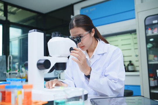 Scientist Conducting Chemical Analysis with Microscope in Laboratory
