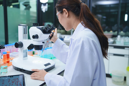 Scientist Conducting Chemical Analysis with Microscope in Laboratory