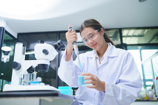 Scientist Conducting Chemical Experiment with Pipette in Laboratory Setting