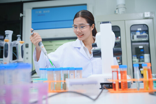 Scientist Conducting Research with Pipette and Test Tubes in Laboratory