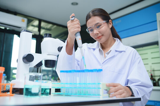 Laboratory Technician Conducting Chemistry Experiment with Pipette and Microscope