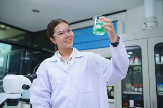 Scientist Conducting Chemical Experiment with Beaker in Laboratory