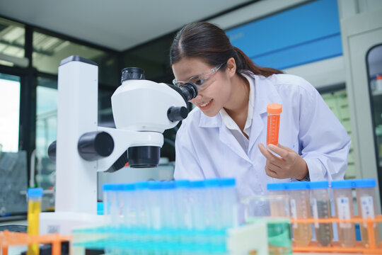Scientist Analyzing Samples with Microscope in Laboratory