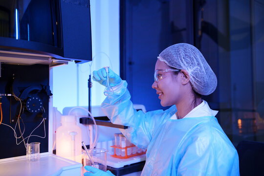 Scientist Performing Chemical Experiment with Glassware in Laboratory