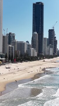 Aerial drone view over Surfers Paradise beach, esplanade and apartment towers, Gold Coast, Queensland Australia - vertical video