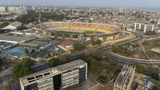 Aerial view of Accra Sports Stadium with its distinctive oval shape, surrounding urban infrastructure, and nearby tennis courts in Accra, Greater Accra Region, Ghana.