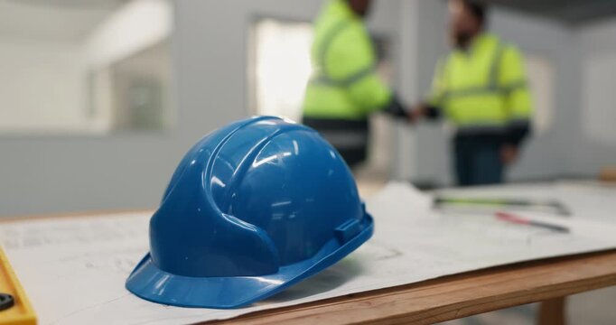 Architect, people and construction helmet with handshake on site for building agreement or deal. Safety, civil engineer or shaking hands with hard hat for architecture security, b2b or protection