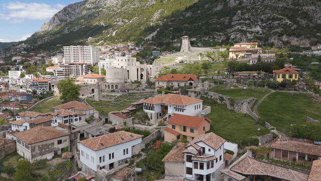 Aerial view of the historic Kruja Castle and surrounding town with traditional red-tiled roofs nestled against a mountainous landscape in Kruje, Durres County, Albania.