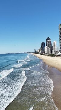 Surfers Paradise aerial drone footage over the beach, surf and high-rise skyline, Gold Coast, Queensland Australia - vertical video