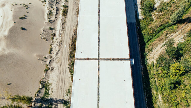 20 July 2026: Aerial view of a concrete bridge structure under construction, flanked by sandy terrain on one side and lush green vegetation on the other.