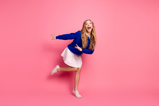 Young woman in blue sweater and pink background joyful playful pose for fashion and lifestyle
