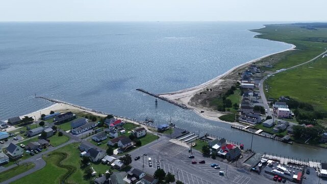 Small fishing community on Delaware coastline at Bowers Beach with marina and inlet waterway with natural wetlands