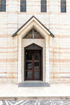 Capernaum, North District, Israel - 08 March 2015: View of the entrance of the Church of the Primacy of St. Peter with its stone facade, wooden doors, and Mater Ecclesiae inscription.