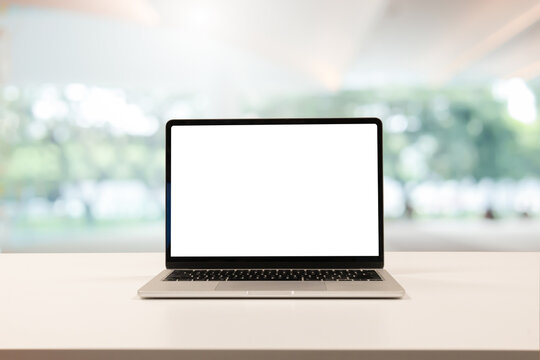 close up isolated on blank white screen display of laptop computer on table inside office room for add content of design banner , website or template or online shopping e-commerce concept