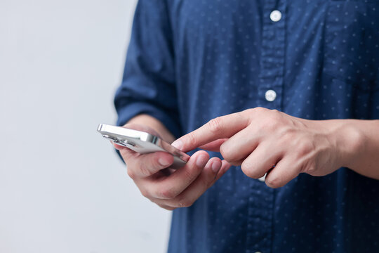 close up businessman hand hold smartphone to surfing the internet and check work or mail on website while sit in the living room in weekend for business technology and lifestyle concept