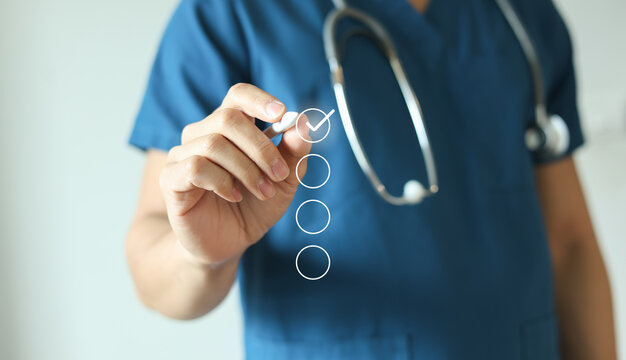 close up young general practitioner hand use stylus pen to check box on medical chekclist or opd record to read and diagnose and assess about patient's symptom for healthy and lifestyle concept