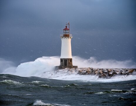 a lighthouse stands resilient against a fierce blizzard at sea beaconing hope and guidance through the storm