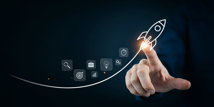 Hand launching a glowing rocket ship drawing with business and technology icons representing startup success and innovation