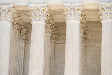 Fototapeta premium Marble pillars highlight timeless architecture. Historic government building with massive columns. Classical facade with elegant stone pillars. Court house exterior with refined architecture.