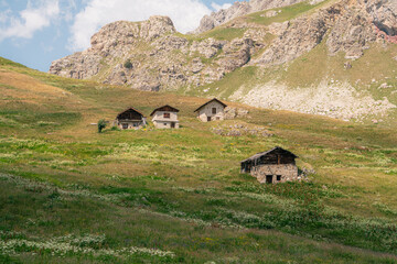 Hameau de chalets en pierre au pied des falaises rocheuses du Queyras © Maxime