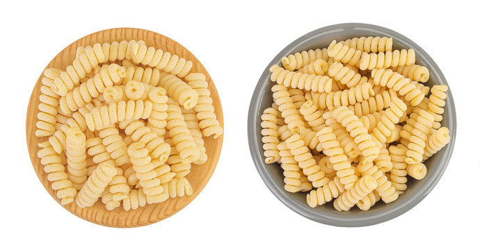 Italian spiral shaped pasta, Fusilli bucati macaroni in wooden and ceramic bowl, isolated on white background. Top view. Flat lay.