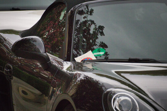 Nahaufnahme von einem Strafzettel hinter dem Scheibenwischer eines Luxusautos der Marke Porsche geparkt im Stadtgebiet &ndash; Landkreis Leipzig, Sachsen, Deutschland