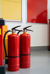 Obraz premium Fire safety and emergency preparedness, two red fire extinguishers standing indoors in a commercial building