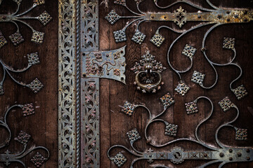 Metal design across an antique wooden door. Metal design with ornamental wrought iron scrollwork....