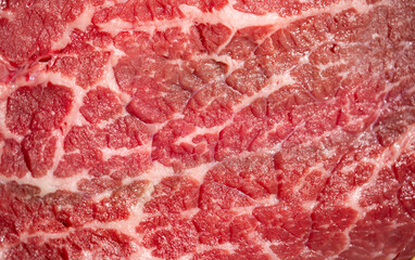 Obraz premium Raw beef texture with natural fat marbling. Raw beef macro background in pink tones. Detailed raw beef surface with muscle fibers. Close-up raw beef forms a food background.