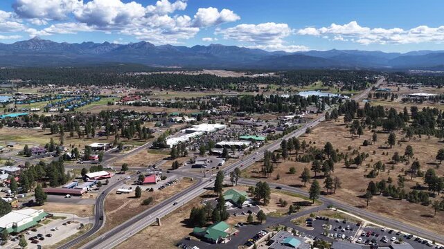 Aerial of US highway 160 through Pagosa Springs Colorado in summer with local roads and commercial buildings and distant mountain views