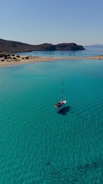 Experience the serene turquoise waters and golden sands of Simos Beach on Elafonisos Island. Enjoy sailing and basking in the sun while surrounded by stunning natural landscapes in Greece.