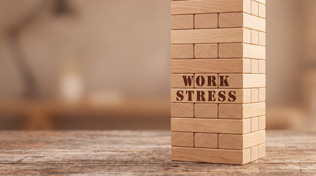 Wooden blocks with work stress text creating a precarious tower, symbolizing job pressure and career challenges