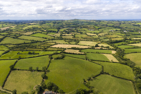 Aerial view of the lush green rolling hills and patchwork fields of the Irish countryside in Cavan, County Cavan, Ireland.