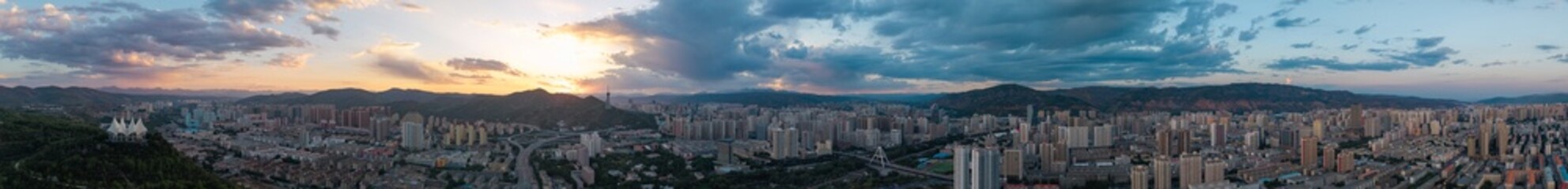 Fototapeta premium Panoramic Cityscape at Dusk with Mountain Backdrop