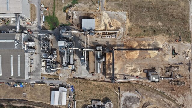 Aerial view of the cardboard and paper factory showing industrial buildings, conveyor belts, and piles of raw materials in Lapovo, Sumadija District, Serbia.