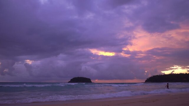 smooth waves hit on the beach at puple sunset.
purple clouds cover the ocean during colorful cloud in sunset at Kata beach Phuket.
video 4K. Scene of pink light in the sky background.