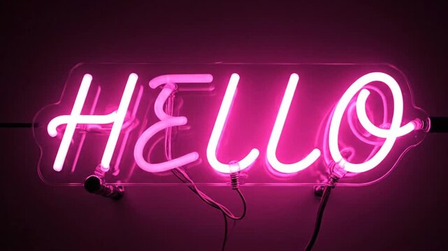 Pink neon 'HELLO' sign glowing brightly on a dark wall