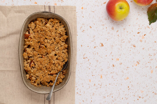 Apple oat crumble in baking dish with autumn leaves