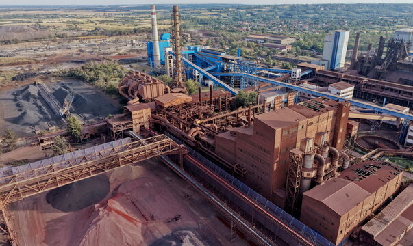 Aerial view of the Smederevo Steelworks featuring industrial structures, blast furnaces, metal pipes, and raw material stockpiles in Smederevo, Podunavlje District, Serbia.